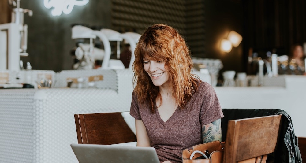 Woman using laptop in cafe