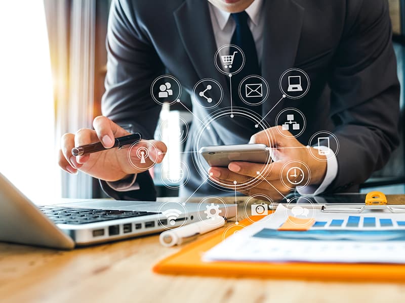 Blog hero image of a government employee in a suit looking at many digital channels for communication represented by icons.