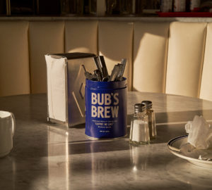 Lifestyle composition of Bub's Brew with cups and napkin dispenser and stark shadows