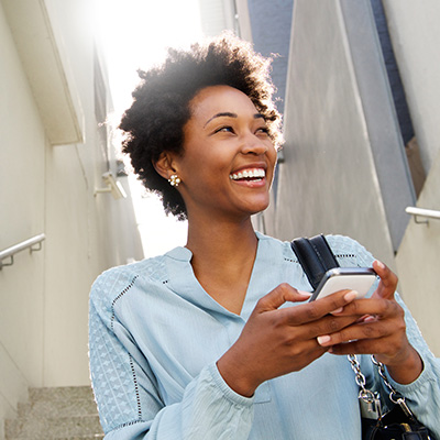 happy woman outdoors using mobile