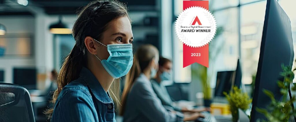 Woman in the office with colleagues wearing a mask during the Covid 19 pandemic